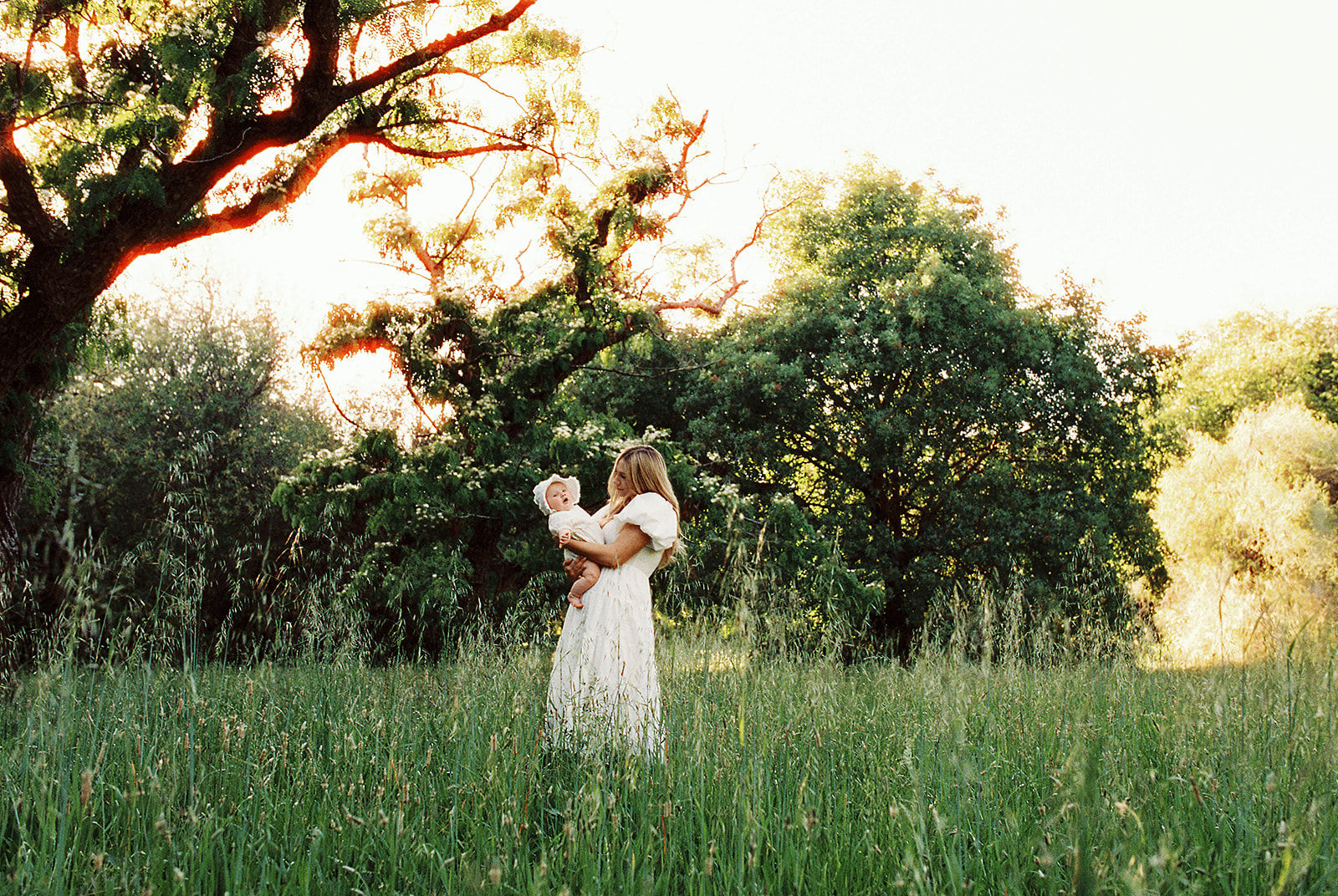mother holding baby in field